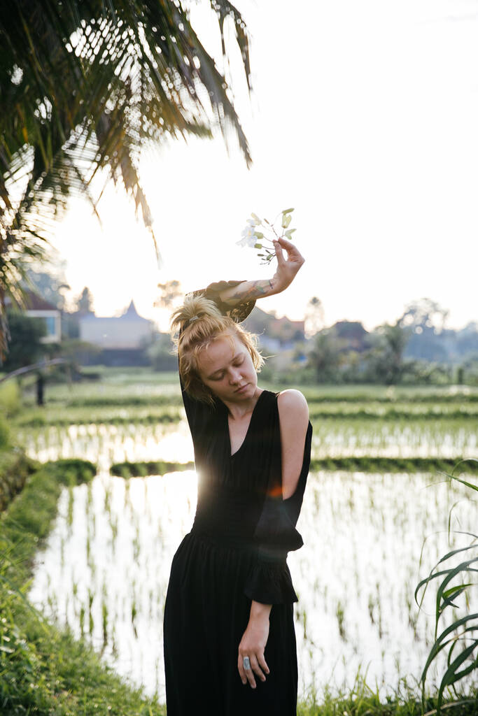 bloguera rubia haciendo yoga y meditación en un campo de arroz mientras viaja en Indonesia a Bali
 - Foto, Imagen