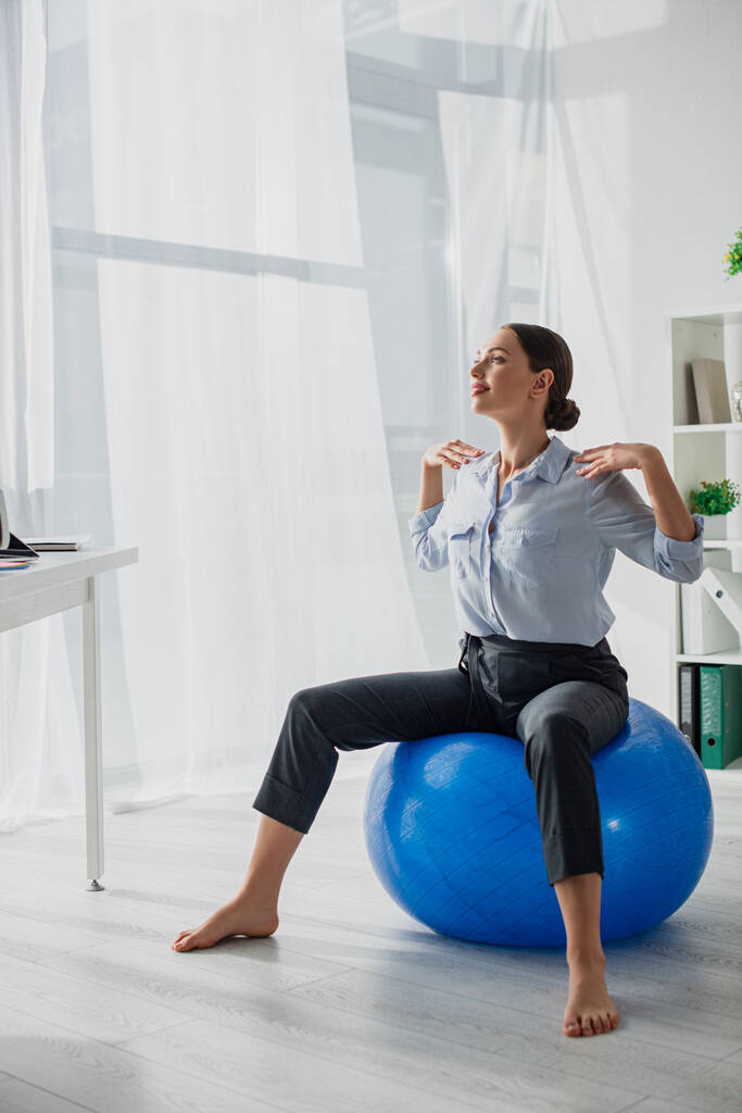 beautiful happy businesswoman exercising on fitness balls in office - Photo, Image
