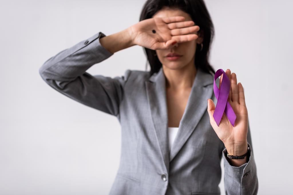 selektivní zaměření podnikatelky s černou tečkou na zakrytí dlaně a držení fialové stuhy izolované na bílé, domácí násilí koncept  - Fotografie, Obrázek