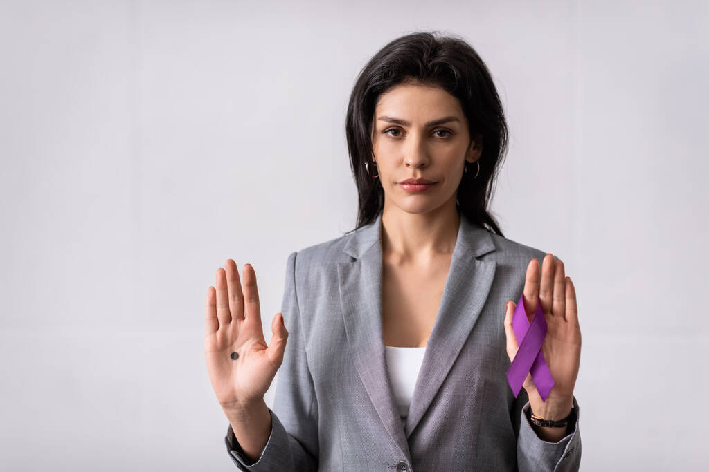 бізнес-леді з чорною крапкою на долоні, що тримає фіолетову стрічку на білому, концепція домашнього насильства
  - Фото, зображення