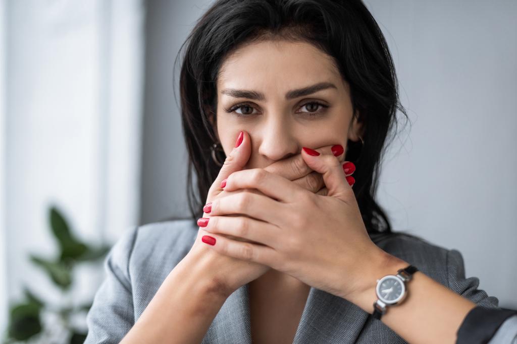 Verärgerte Geschäftsfrau mit Bluterguss, der Mund mit Händen bedeckt, Konzept für häusliche Gewalt  - Foto, Bild
