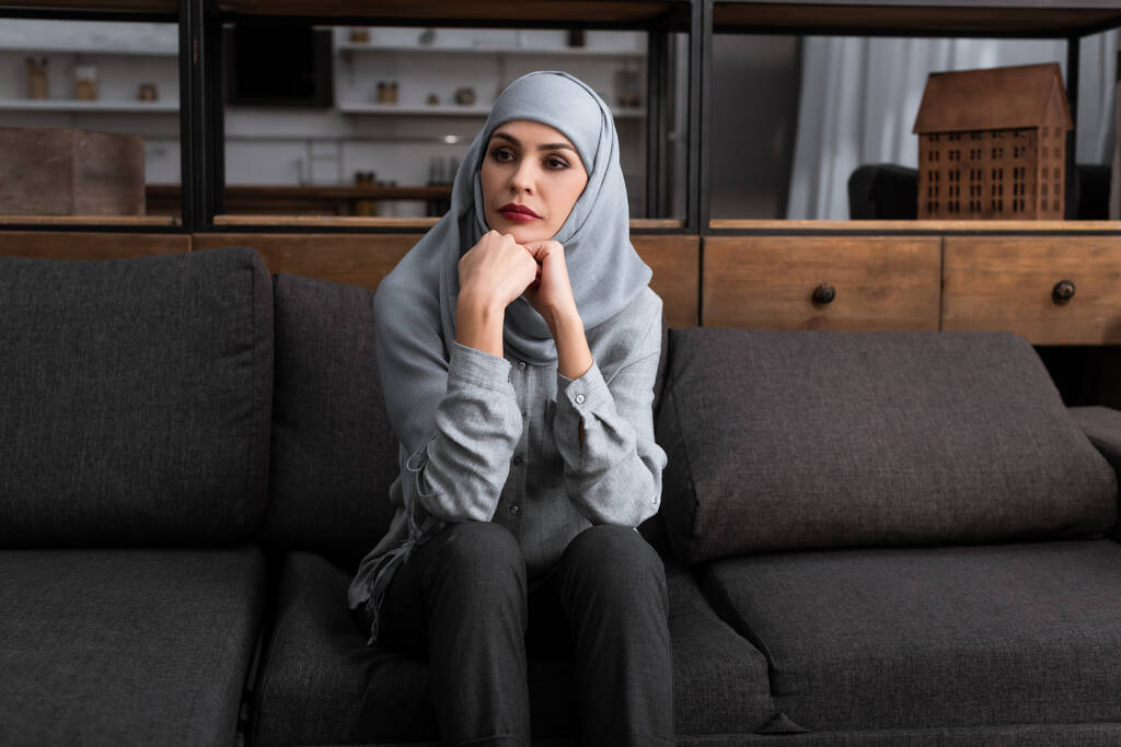 surullinen musliminainen hijabissa istuu sohvalla, perheväkivallan käsite
   - Valokuva, kuva