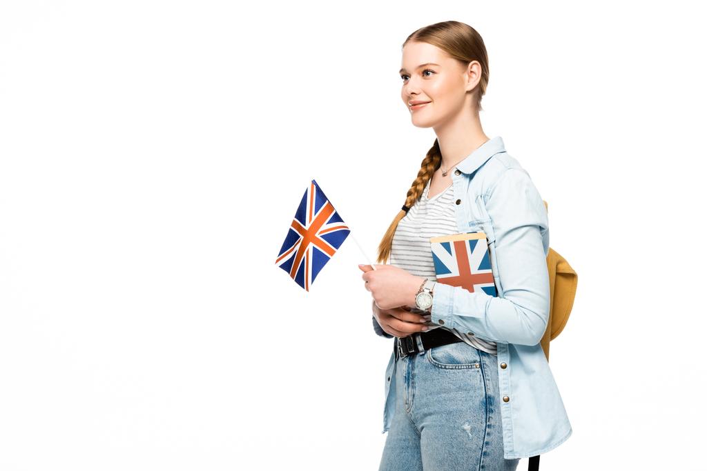 uśmiechnięta ładna studentka z plecakiem z książką i brytyjską flagą odizolowana na białym - Zdjęcie, obraz