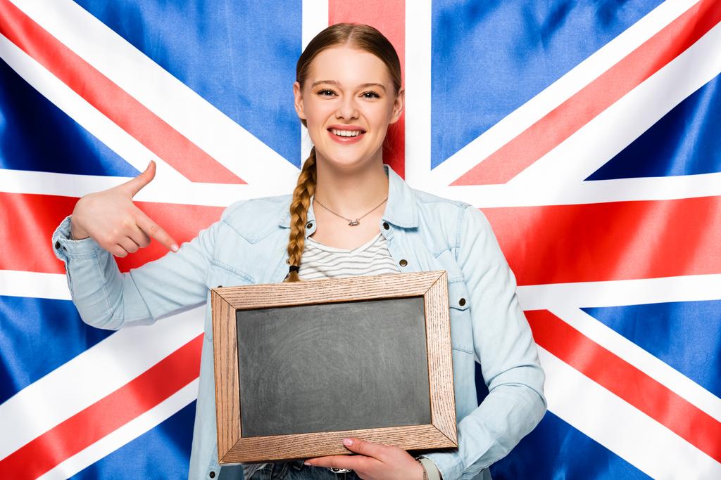 可愛いです女の子ともにブレイドポイントで空の黒板に英国の国旗の背景 - 写真・画像