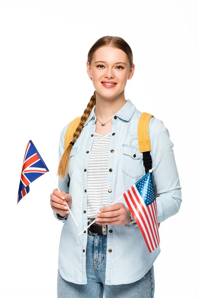 glimlachend meisje met vlecht en rugzak met vlaggen van Amerika en verenigd koninkrijk geïsoleerd op wit - Foto, afbeelding