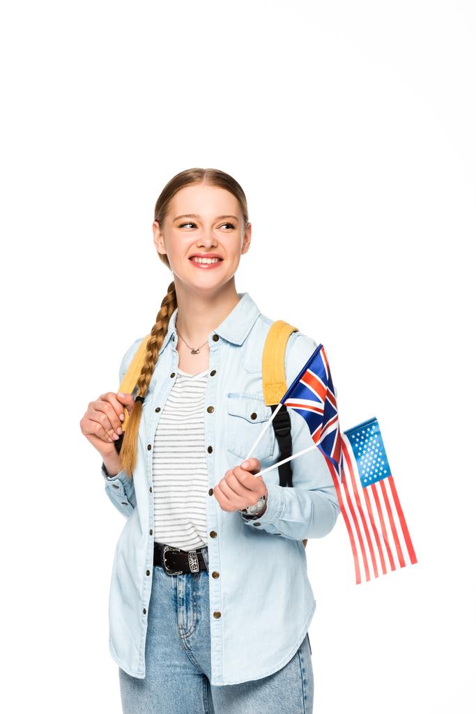 Ευτυχισμένο κορίτσι με πλεξούδες και σακίδιο κρατώντας σημαίες της Αμερικής και του Ηνωμένου Βασιλείου απομονωμένο σε λευκό - Φωτογραφία, εικόνα