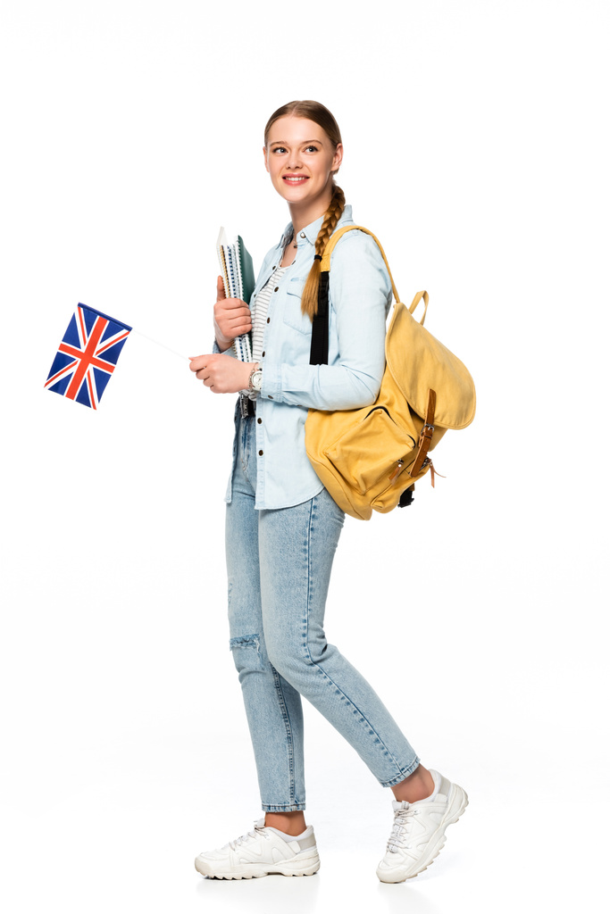 χαμογελαστό κορίτσι με σακίδιο κρατώντας copybooks και σημαία Ηνωμένο Βασίλειο απομονώνονται σε λευκό - Φωτογραφία, εικόνα