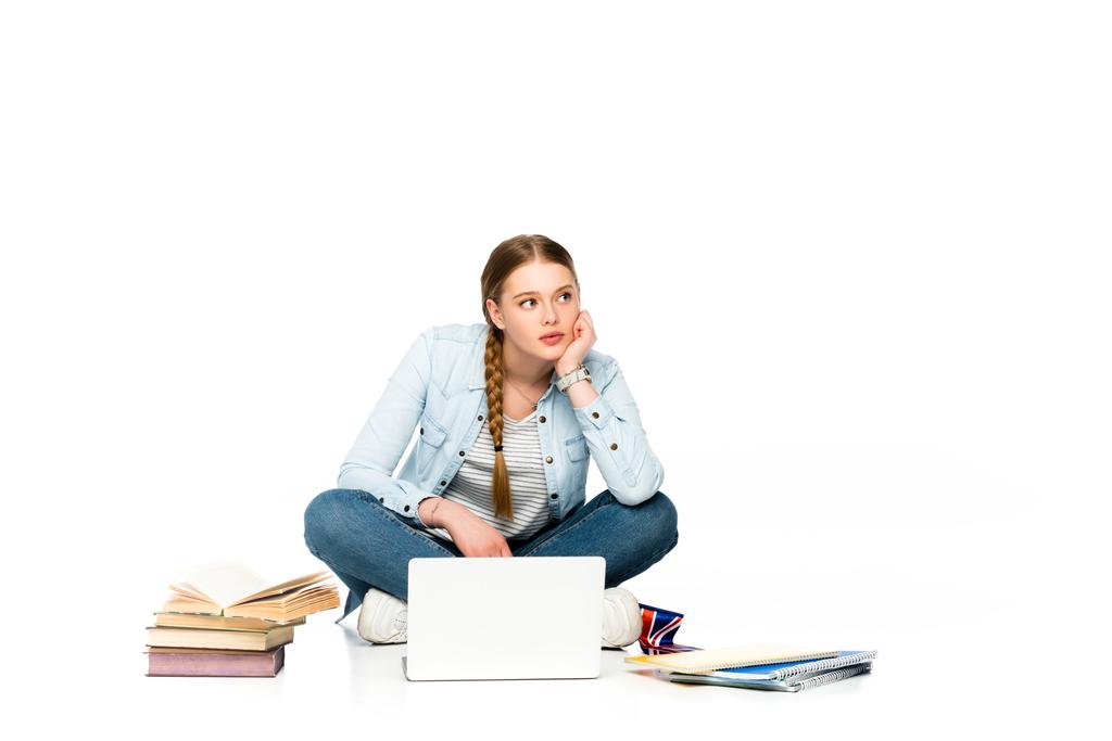 Düşünceli kız dizüstü bilgisayarında, kitaplarında ve defterlerinde İngiliz bayrağını beyaza sarmış şekilde yerde oturuyor. - Fotoğraf, Görsel