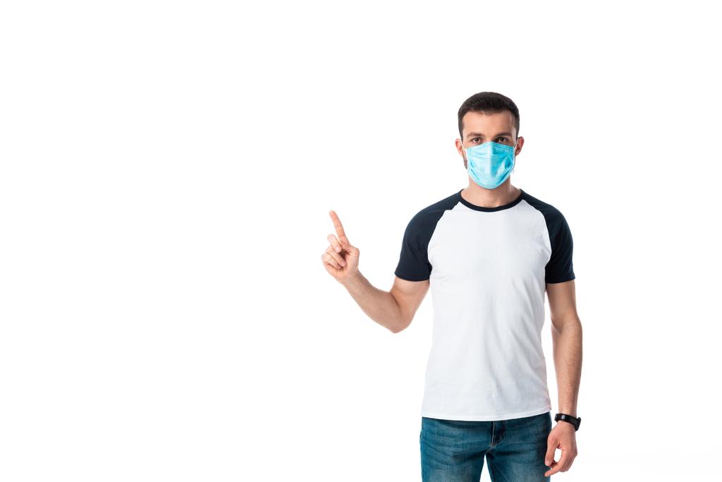 άνδρας με ιατρική μάσκα που δείχνει με το δάχτυλο απομονωμένο σε λευκό  - Φωτογραφία, εικόνα