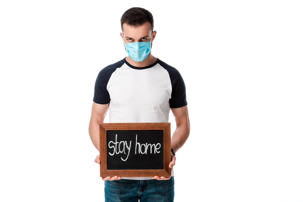 uomo in maschera medica tenendo bordo gesso con soggiorno casa lettering isolato su bianco
  - Foto, immagini