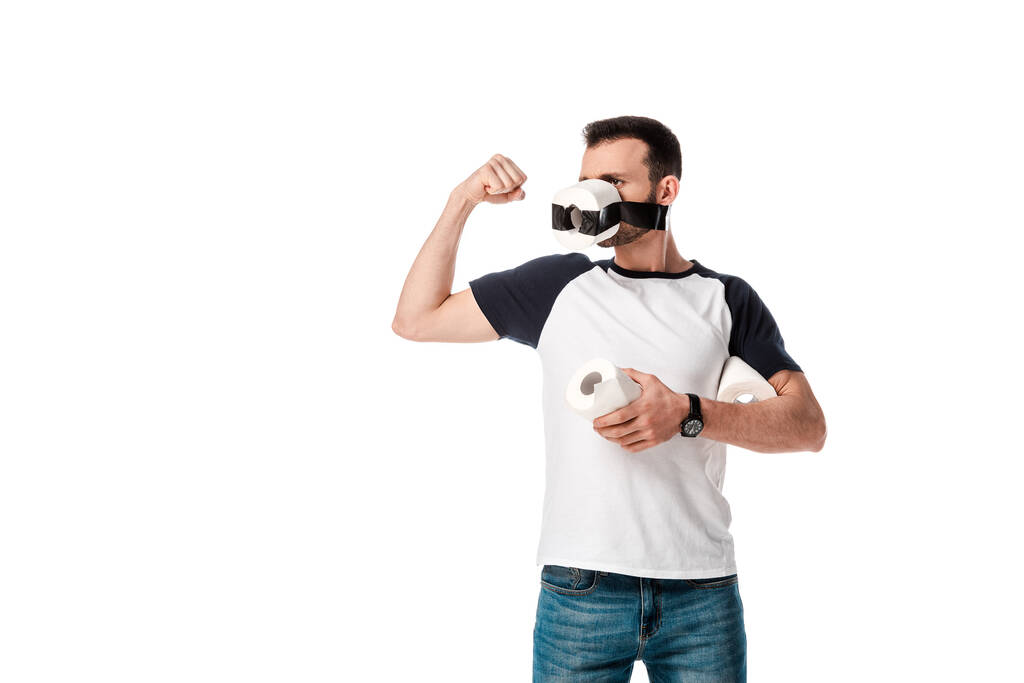 uomo con scotch nastro e carta igienica sul viso tenendo rotolo di carta morbida e mostrando muscolo isolato su bianco
  - Foto, immagini