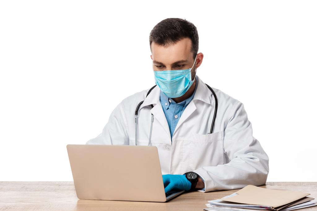 ホワイトに隔離されたノートパソコンを使った医療用マスクの医者  - 写真・画像