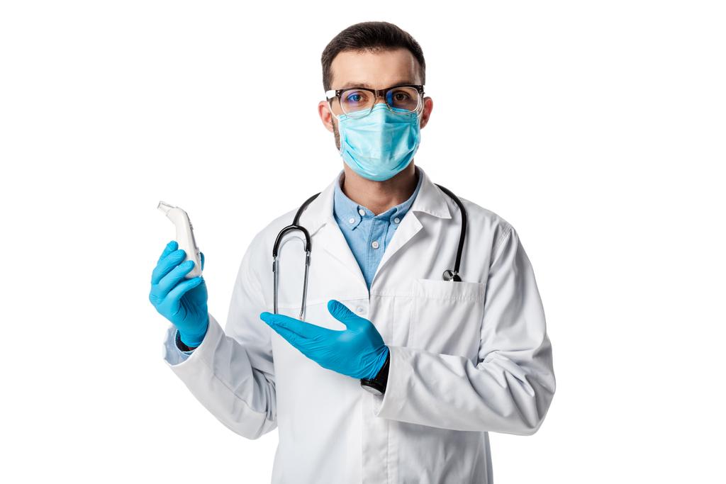 medico in maschera medica e mantello bianco che punta con mano al pirometro senza contatto isolato su bianco
  - Foto, immagini