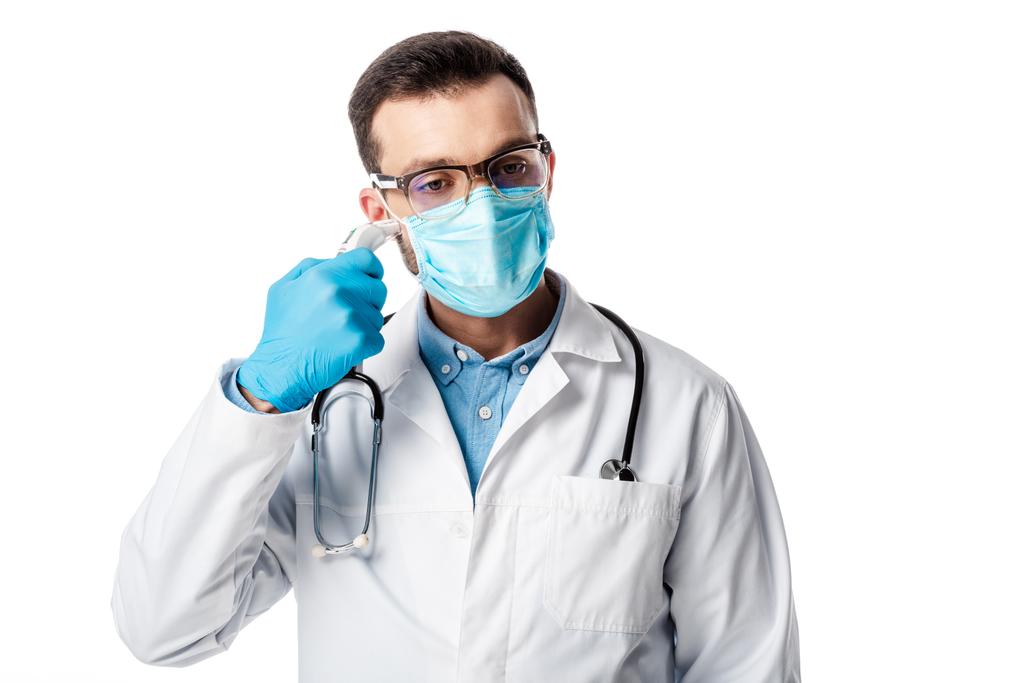 врач в медицинской маске и белом халате с помощью пирометра, изолированного на белом
  - Фото, изображение