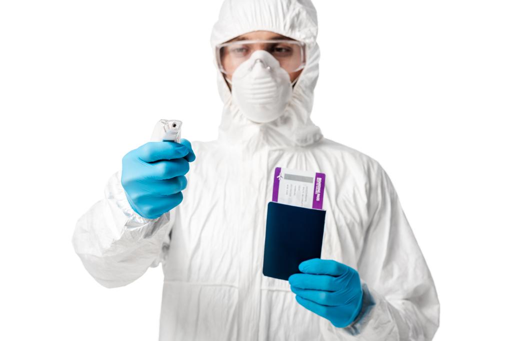 selective focus of man in hazmat suit holding pyrometer and passport with boarding pass isolated on white  - Photo, Image
