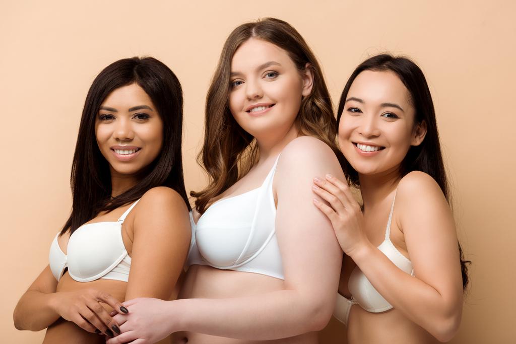 donne multiculturali sorridenti e sovrappeso in reggiseni isolati sul beige
  - Foto, immagini