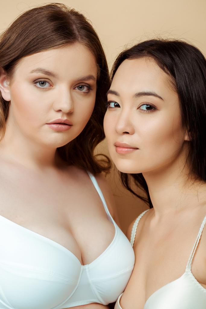 mooi overgewicht vrouw en aziatisch meisje in ondergoed geïsoleerd op beige, lichaam positief concept  - Foto, afbeelding