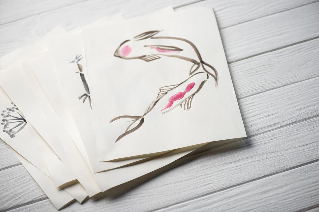 Hochwinkelaufnahme von Papier mit japanischer Malerei auf Holzoberfläche - Foto, Bild