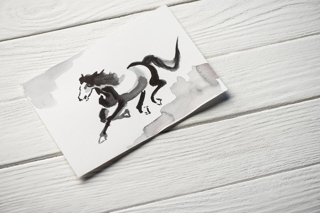 木製の背景に馬と日本画と紙のトップビュー - 写真・画像