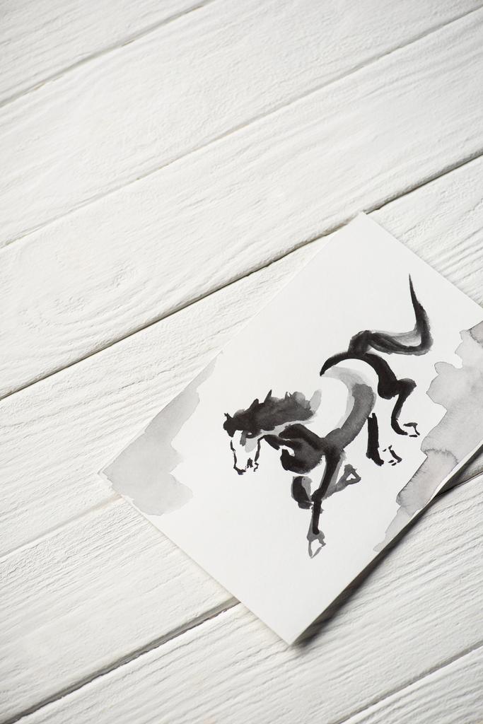 Widok z góry papieru z japońskim malarstwem z szarym koniem na drewnianym tle - Zdjęcie, obraz