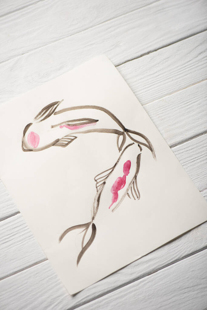Υψηλή γωνία άποψη του χαρτιού με ιαπωνική ζωγραφική με ψάρια σε ξύλινο φόντο - Φωτογραφία, εικόνα