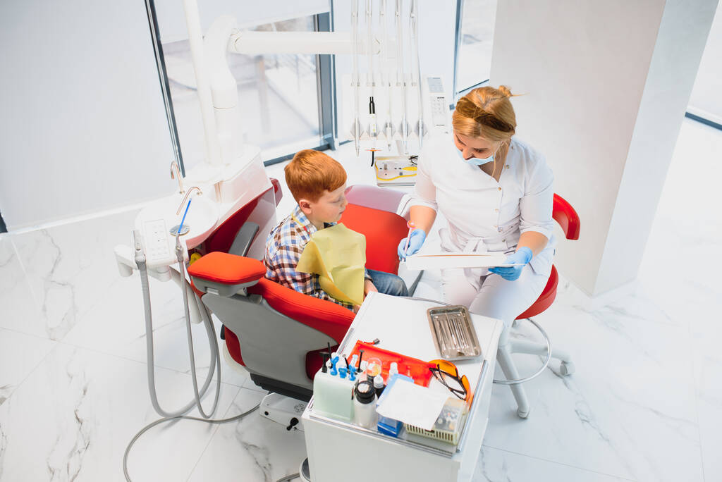 Жінка-стоматолог і дитина в кабінеті стоматолога
 - Фото, зображення