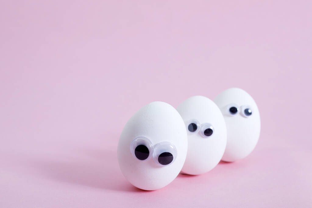 концепция общения в социальных сетях и эмоции - яйца подмигивают на розовом фоне. Копирование пространства
 - Фото, изображение