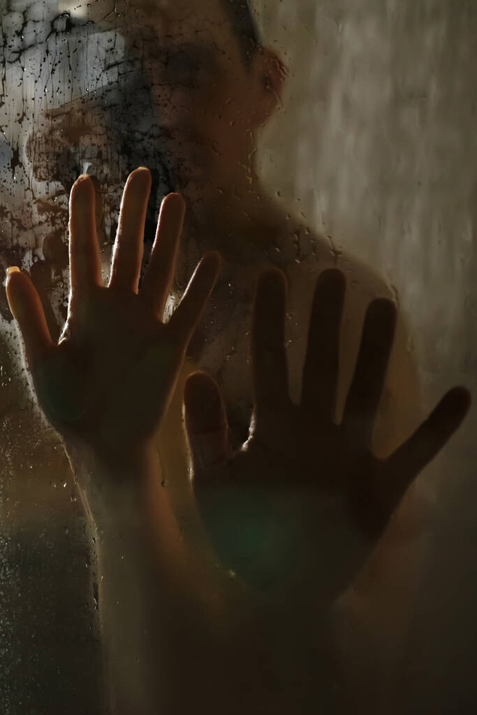 Ręce mężczyzny i kobiety na mokrym szkle pod prysznicem. Zbliżenie. - Zdjęcie, obraz