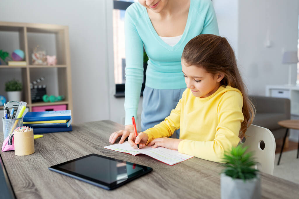 mother and daughter with tablet pc doing homework - Photo, Image