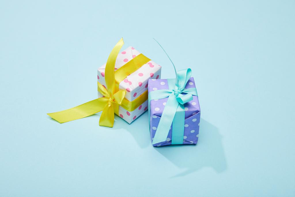 διακεκομμένα εορταστικά πολύχρωμα κουτιά δώρων σε μπλε φόντο - Φωτογραφία, εικόνα