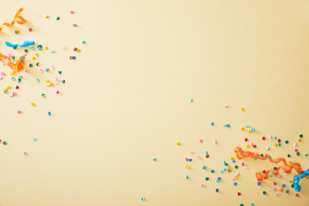 vista superior de confeti colorido festivo sobre fondo beige
 - Foto, imagen