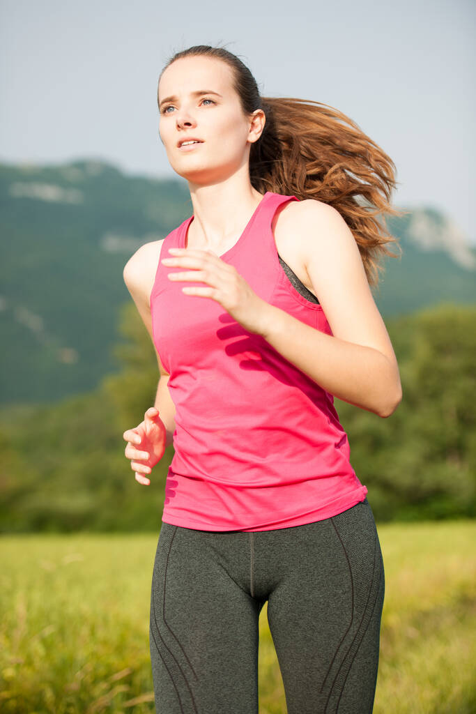 Gyönyörű fiatal nő edzés szabadtéri fut át rét kora nyáron - Fotó, kép