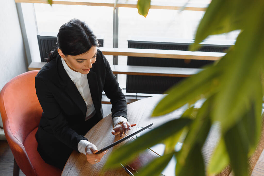 Портрет элегантной деловой женщины с планшетным ПК в светлом современном офисе
 - Фото, изображение