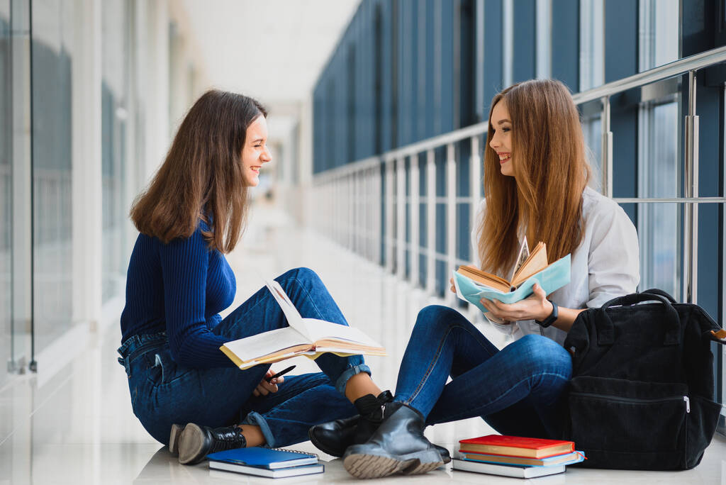 Női diákok ül a padlón, és olvasás jegyzetek vizsga előtt - Fotó, kép