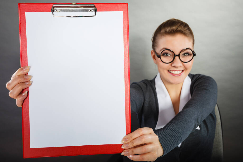 Hírek és információk az üzleti életben. Elegáns szőke fiatal nő piros üres írótáblával és fehér papírral. - Fotó, kép