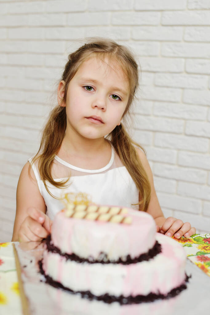 vážná malá narozeninová holčička s dortem - Fotografie, Obrázek