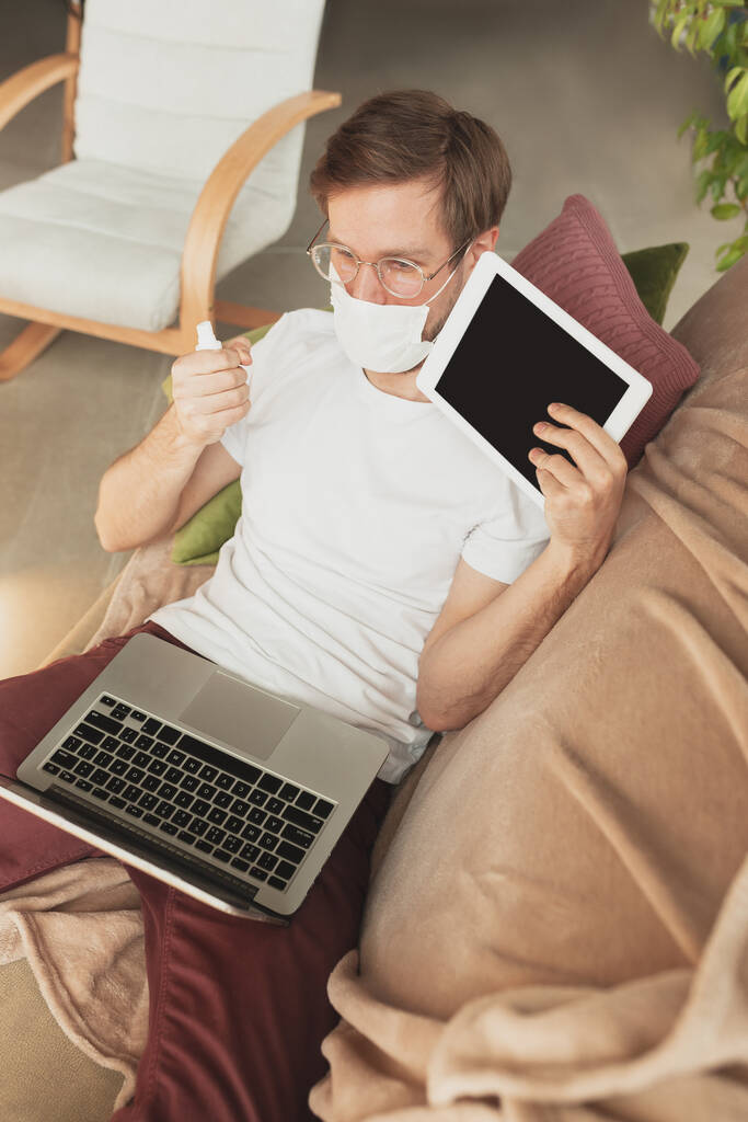 Fiatal férfi tanul otthon online tanfolyamok fertőtlenítő, nővér, orvosi szolgáltatások - Fotó, kép