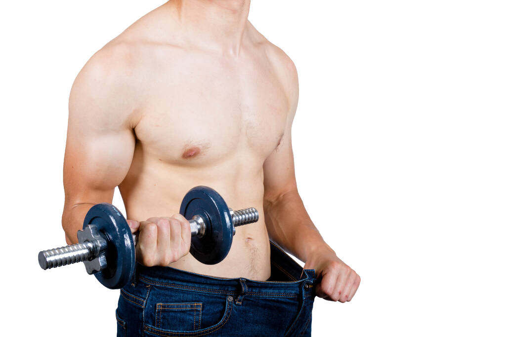 Потеря веса концепция показывает мускулистый молодой мужчина держит положить мешковатую одежду и держа гантель
 - Фото, изображение