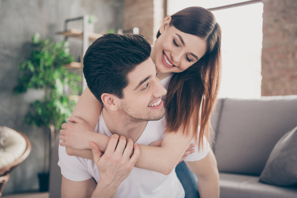 Close-up portrait of nice attractive lovely cute gentle affectionate cheerful cheery couple sitting on divan embracing having fun honeymoon at modern industrial loft style brick interior house - Photo, Image