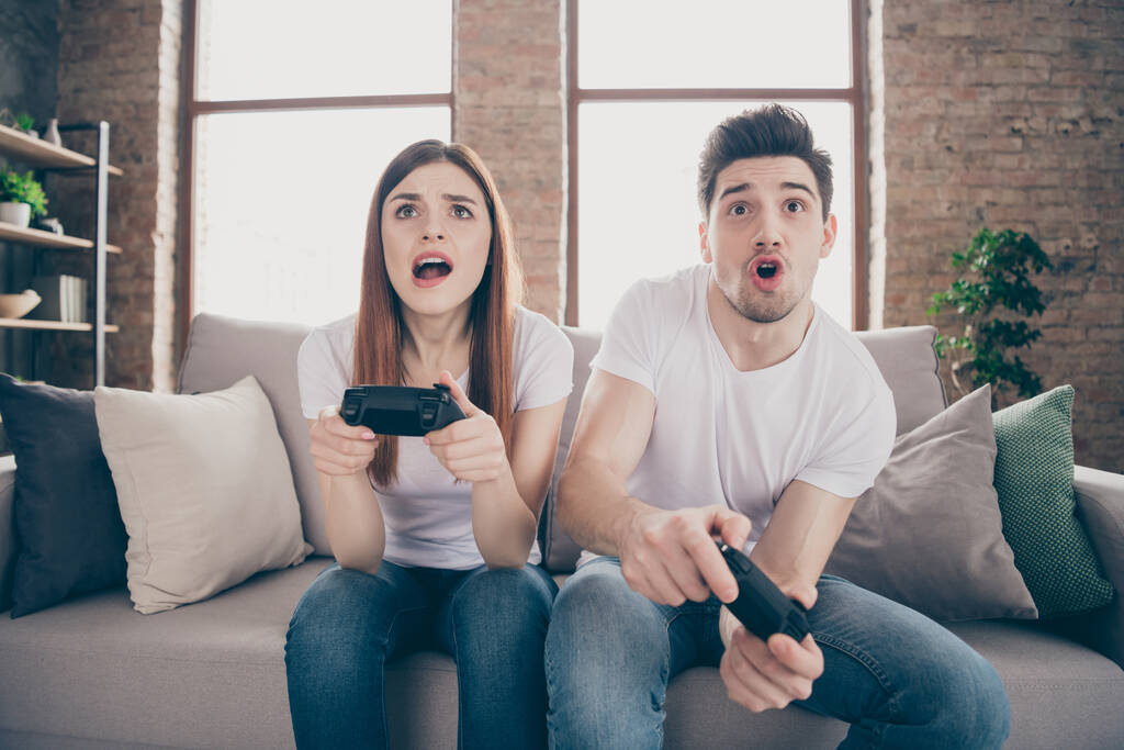 Portrait of her she his he attractive focused concentrated worried friends friendship sitting on divan playing online game having fun at modern industrial loft style brick interior house - Photo, Image