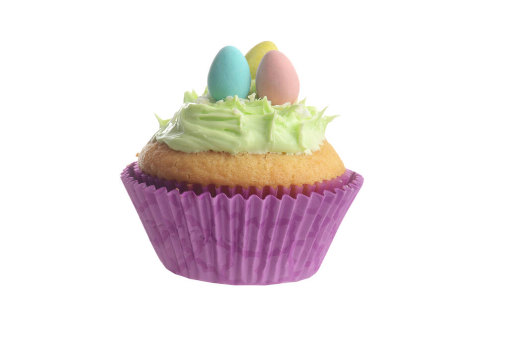 緑の霜降りとミニ卵と隔離されたイースターカップケーキ - 写真・画像
