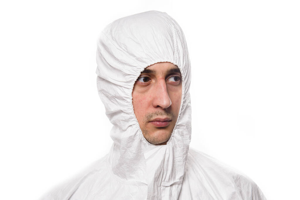 Porträt eines jungen Mannes in weißer Schutzuniform während der Coronavirus-Pandemie. Epidemie, Coronavirus-Pandemie 19. - Foto, Bild