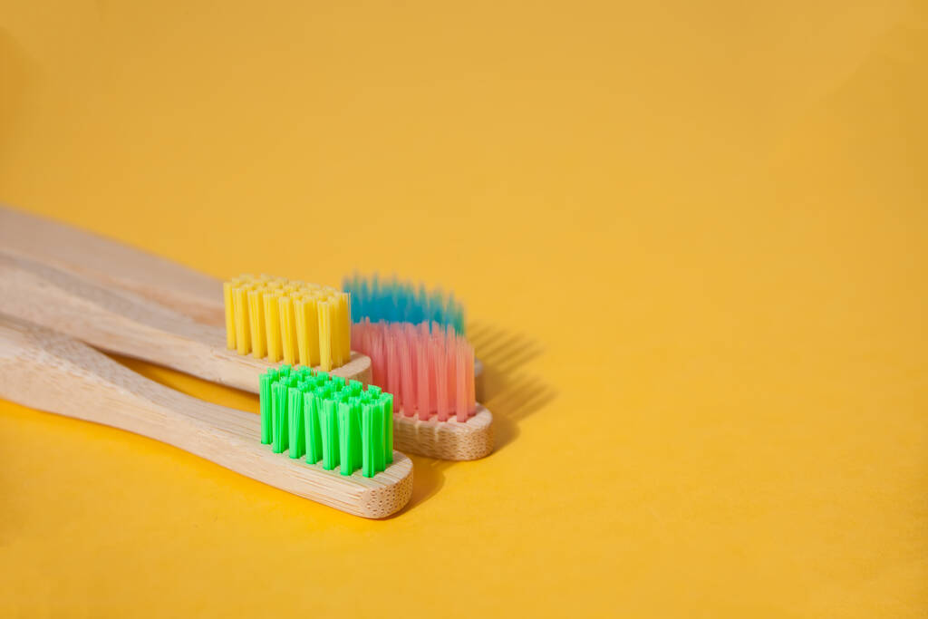 Öko-Bambus-Kind bunte Zahnbürsten auf gelbem Hintergrund. Kopierraum. - Foto, Bild
