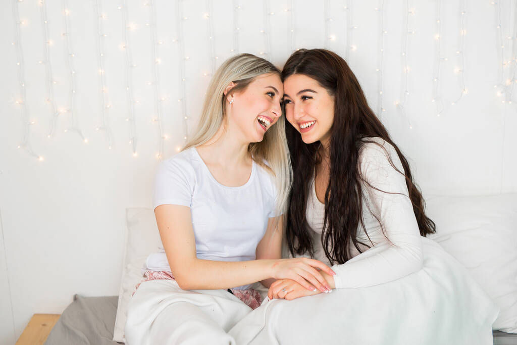 Дві красиві молоді жінки на ліжку
 - Фото, зображення