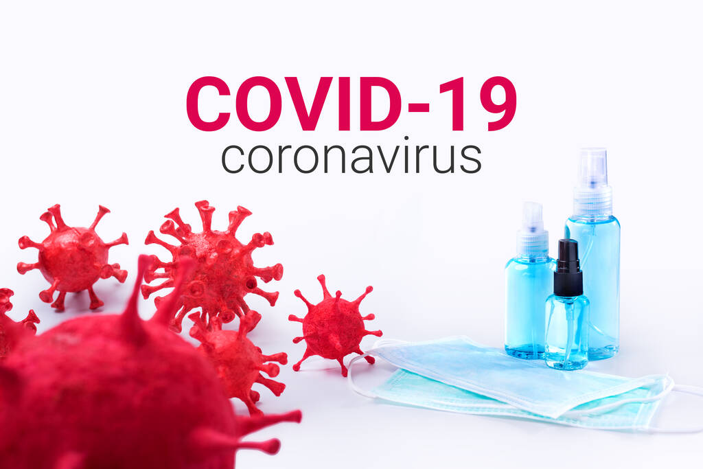 Coronavirus (COVID-19) dat is gebouwd door het gieten van klei geschilderd heeft chirurgische maskers en alcohol hand ontsmetter gel voor hygiëne verspreid bescherming. - Foto, afbeelding