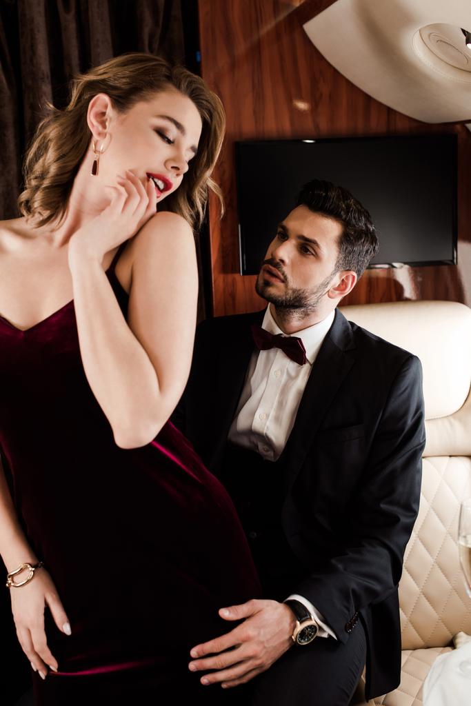 pohledný, elegantní muž dotýkající se svůdné, flirtující žena v rovině - Fotografie, Obrázek