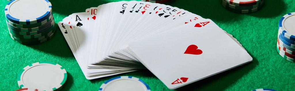 緑の背景にカジノチップとカードのパックの高角度ビュー パノラマショット ロイヤリティフリー写真 画像素材