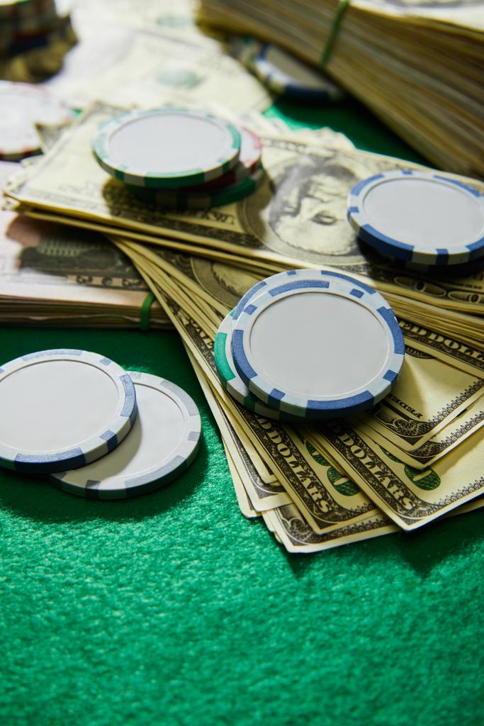 Selektiver Fokus von Dollarnoten und Casino-Chips auf grünem Hintergrund - Foto, Bild