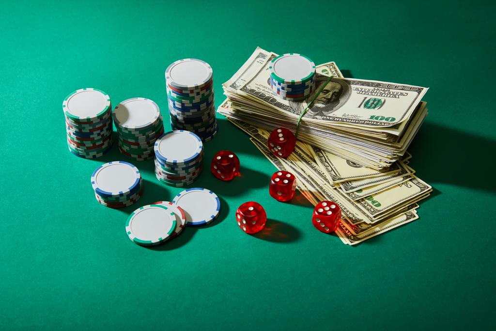 Vista de ángulo alto de billetes de dólar, dados y fichas de casino en verde
 - Foto, Imagen