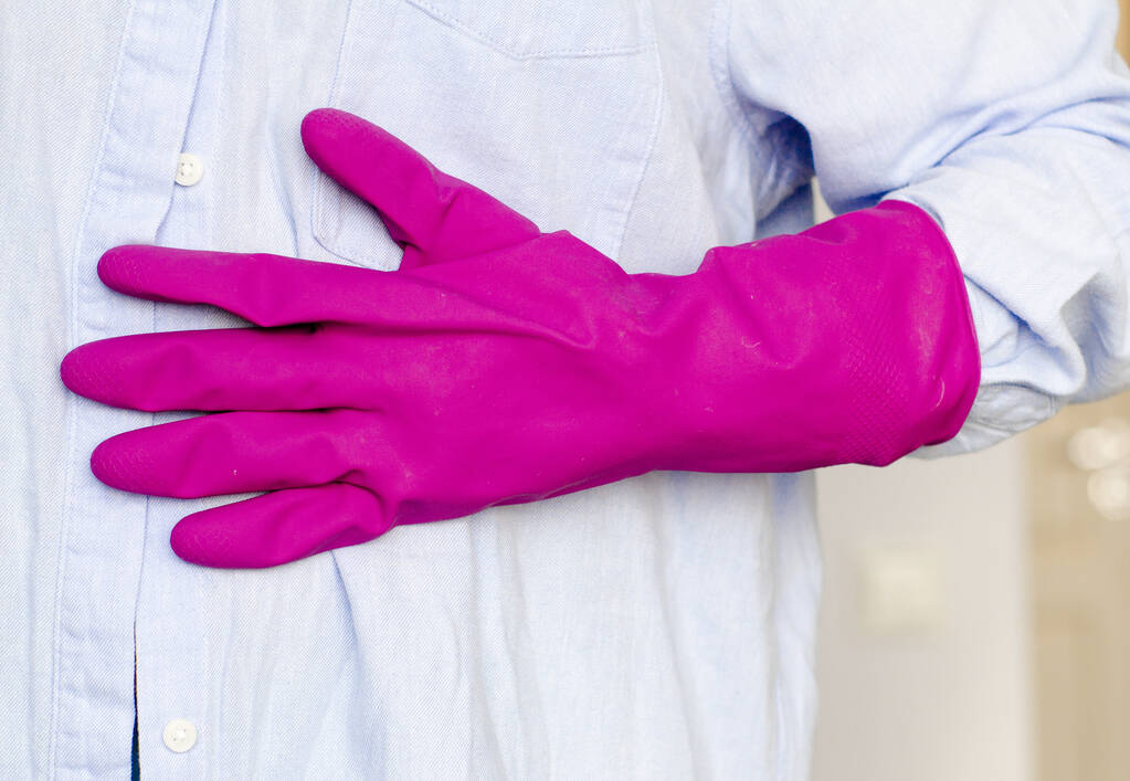 Χέρι σε μωβ γάντι νοικοκυριού σε γαλάζιο φόντο, θέμα καθαρισμού σπιτιού - Φωτογραφία, εικόνα
